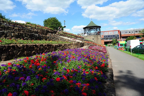 The bandstand behind some red and purple flowers