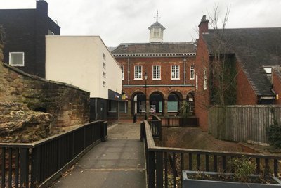 Two buildings separated by a bridge in front of the town hall
