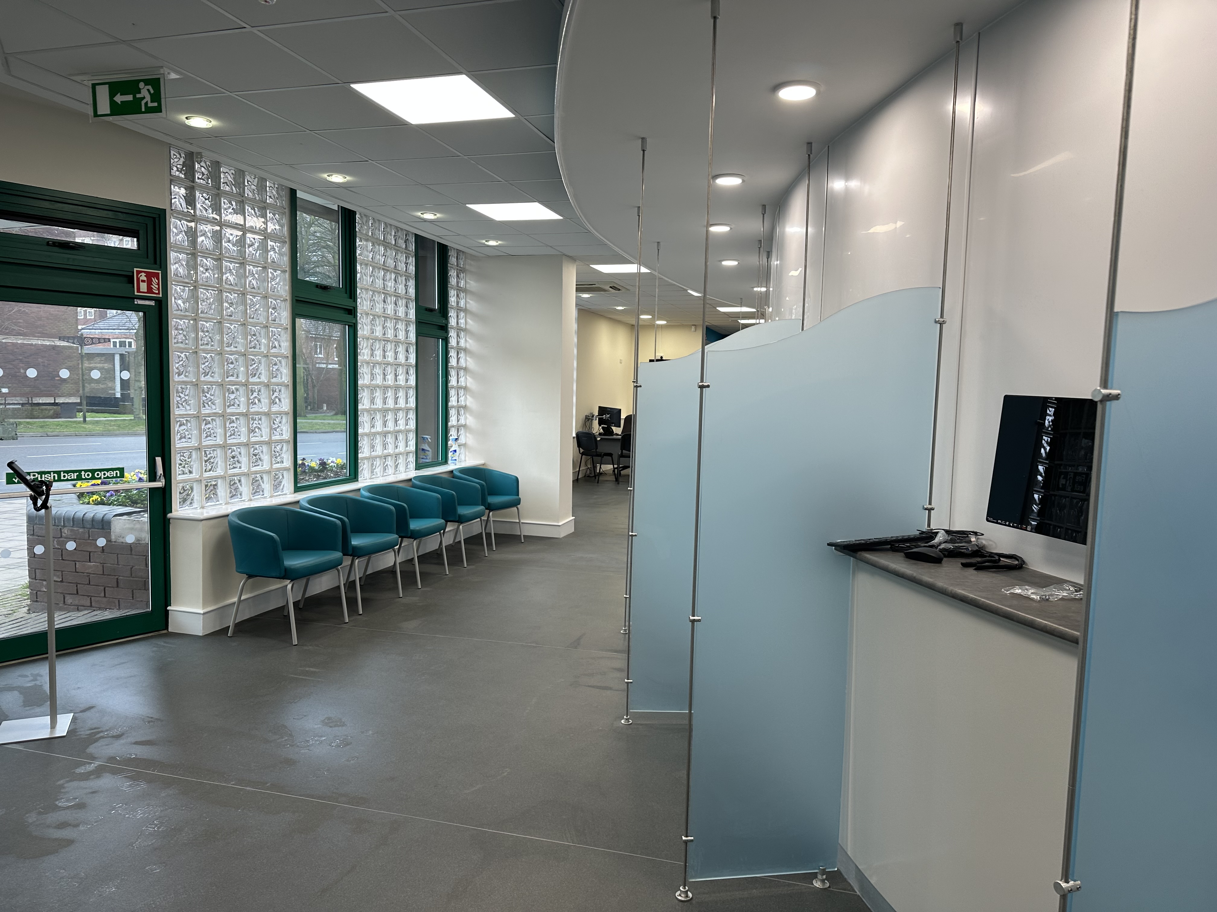 photo of inside reception with blue separating glass and chairs