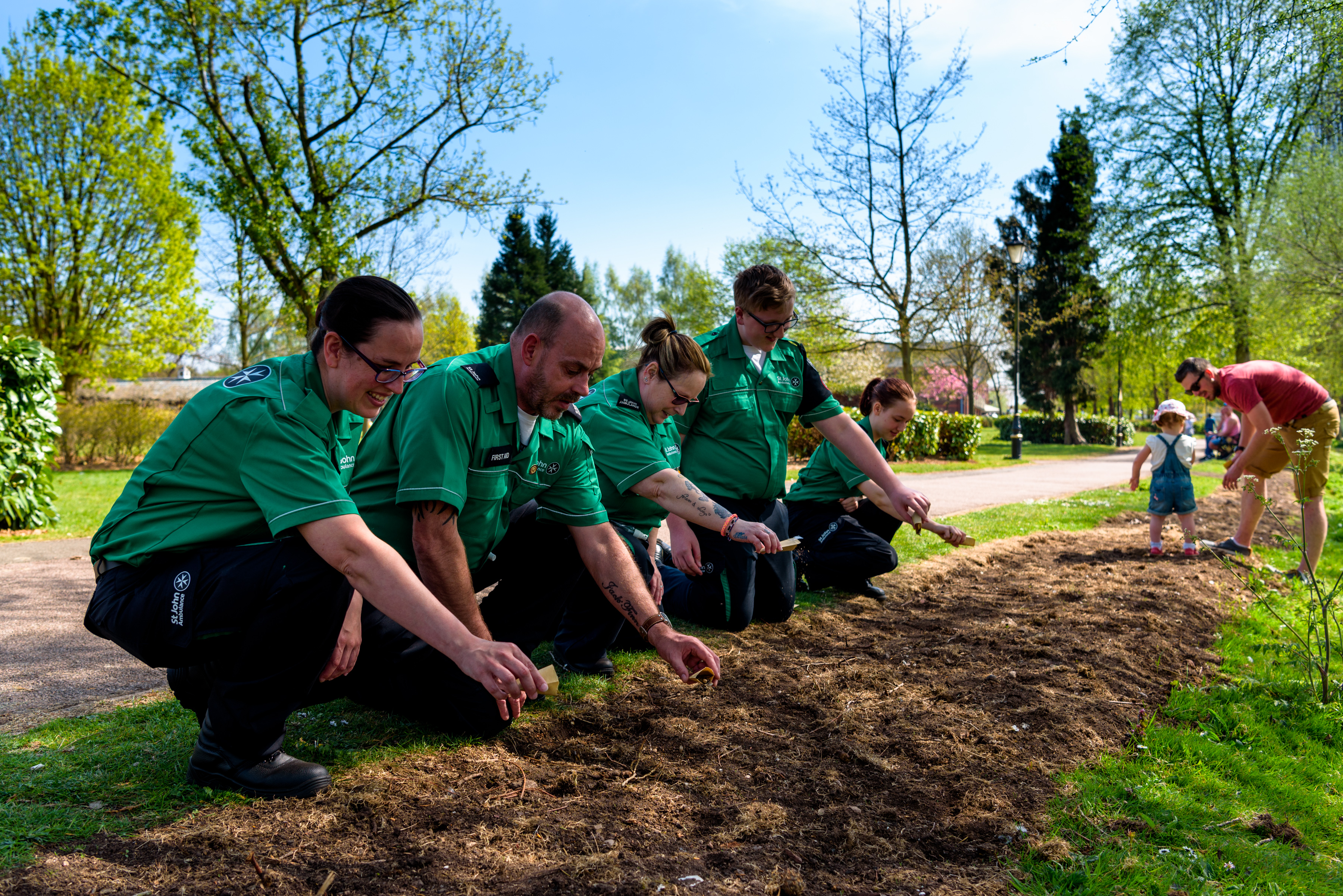 photo of 4 people planting seeds