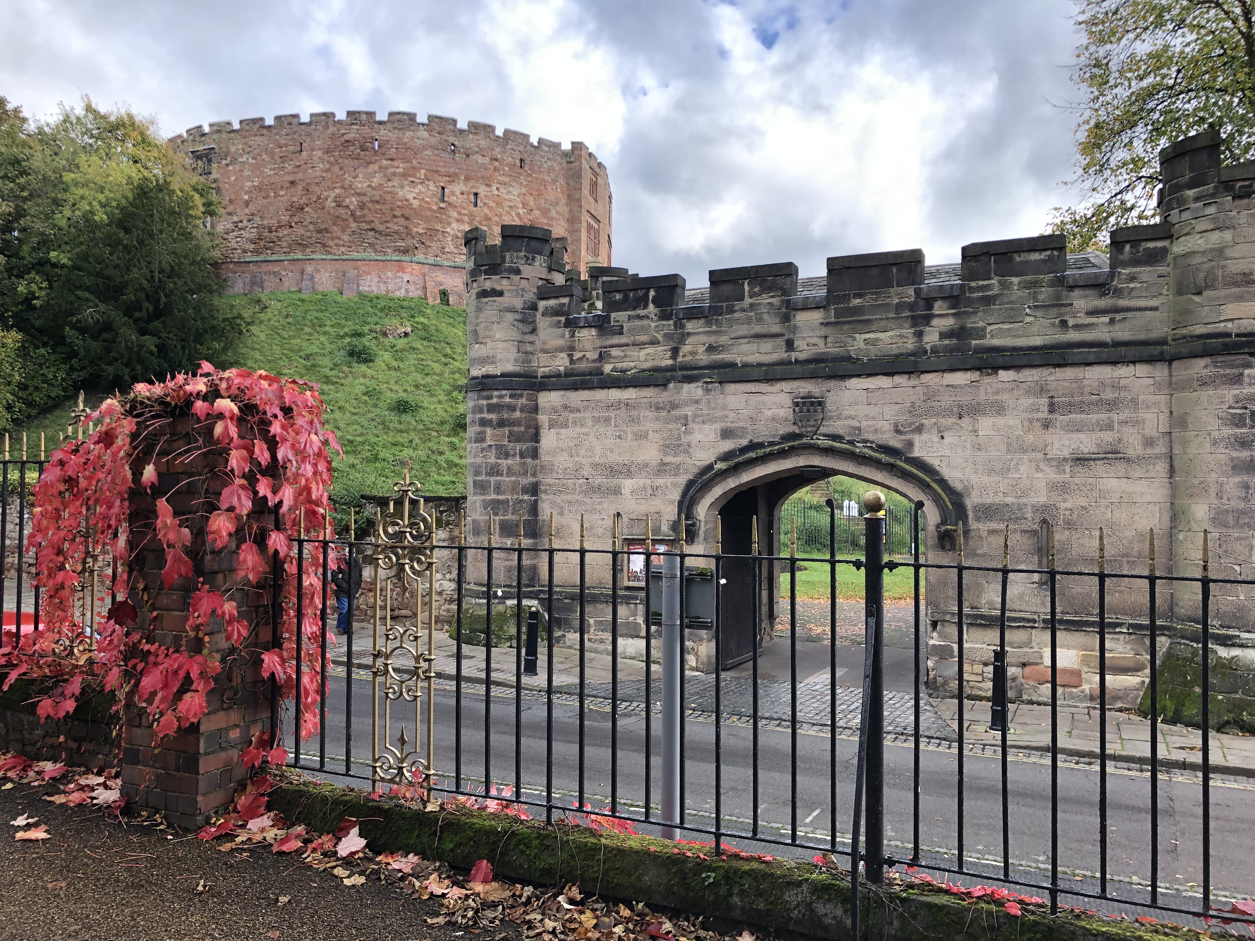 photo of a old turret building and archway with a castle in the background