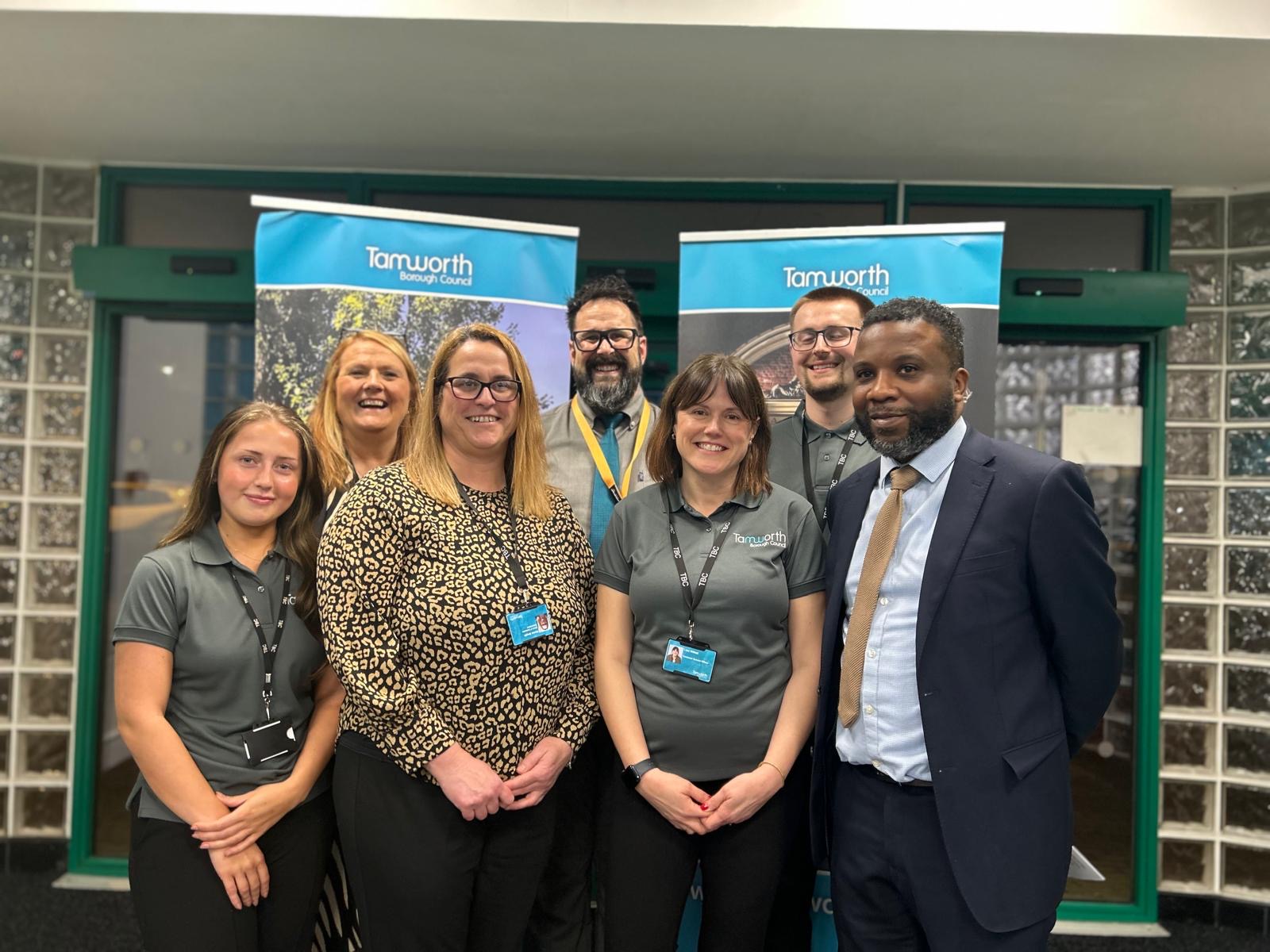 A group of people standing in front of banners and glass doors