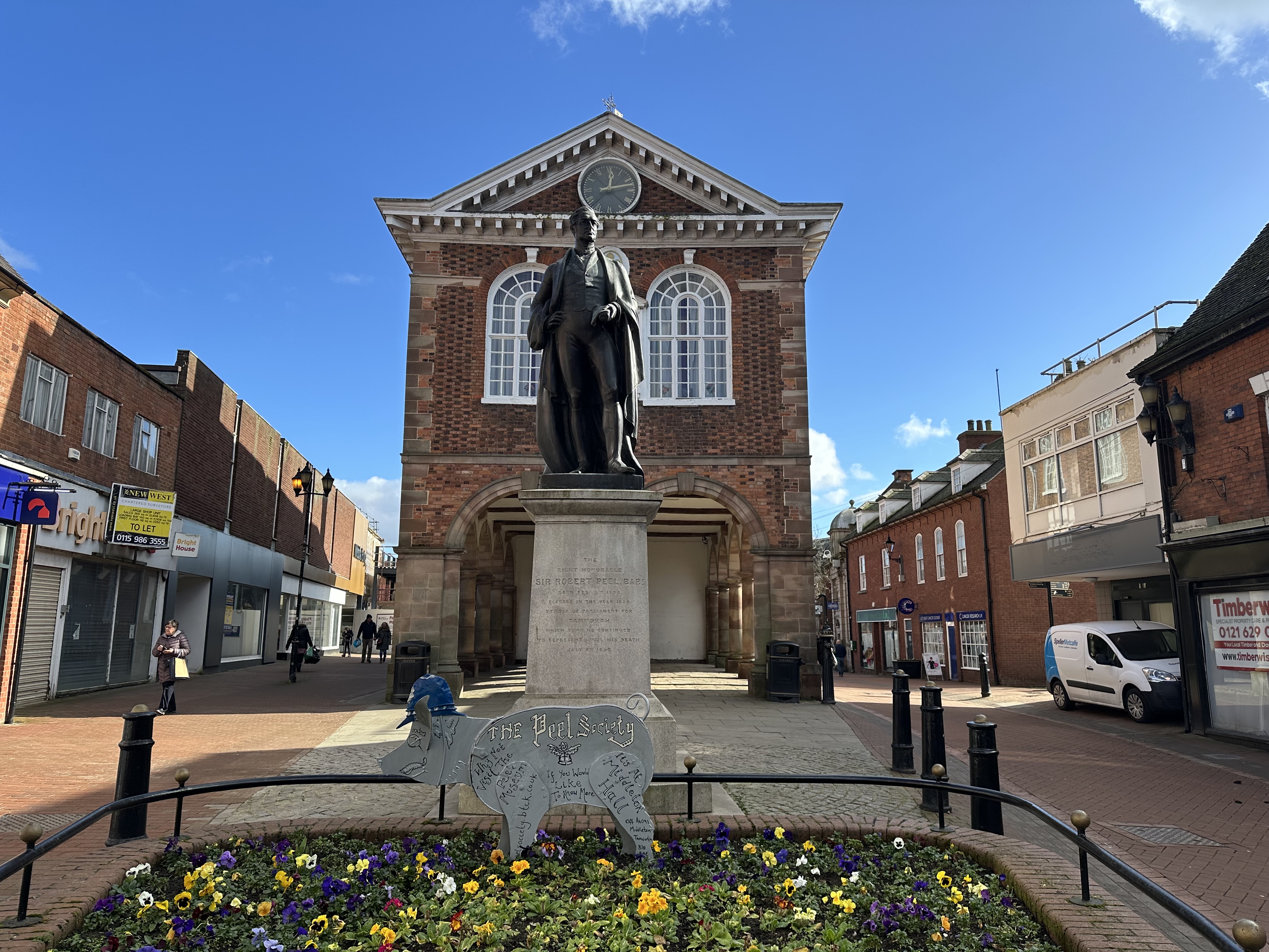 Tamworth town hall with a statue and flowerbed in front of it