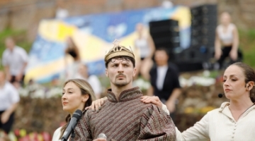 man standing with a mercian flag behind him, wearing a crown 