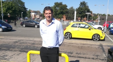 Cllr Cook stood in front of a car park 