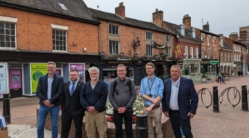 A group of people stood in front of buildings