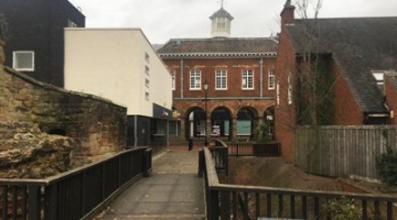 Two buildings separated by a bridge in front of the town hall