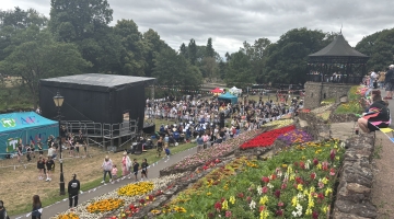 photo of a stage and gazebo on the lower lawn of Tamworth Castle Grounds with crowds of people