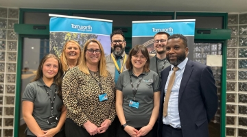 A group of people standing in front of banners and glass doors